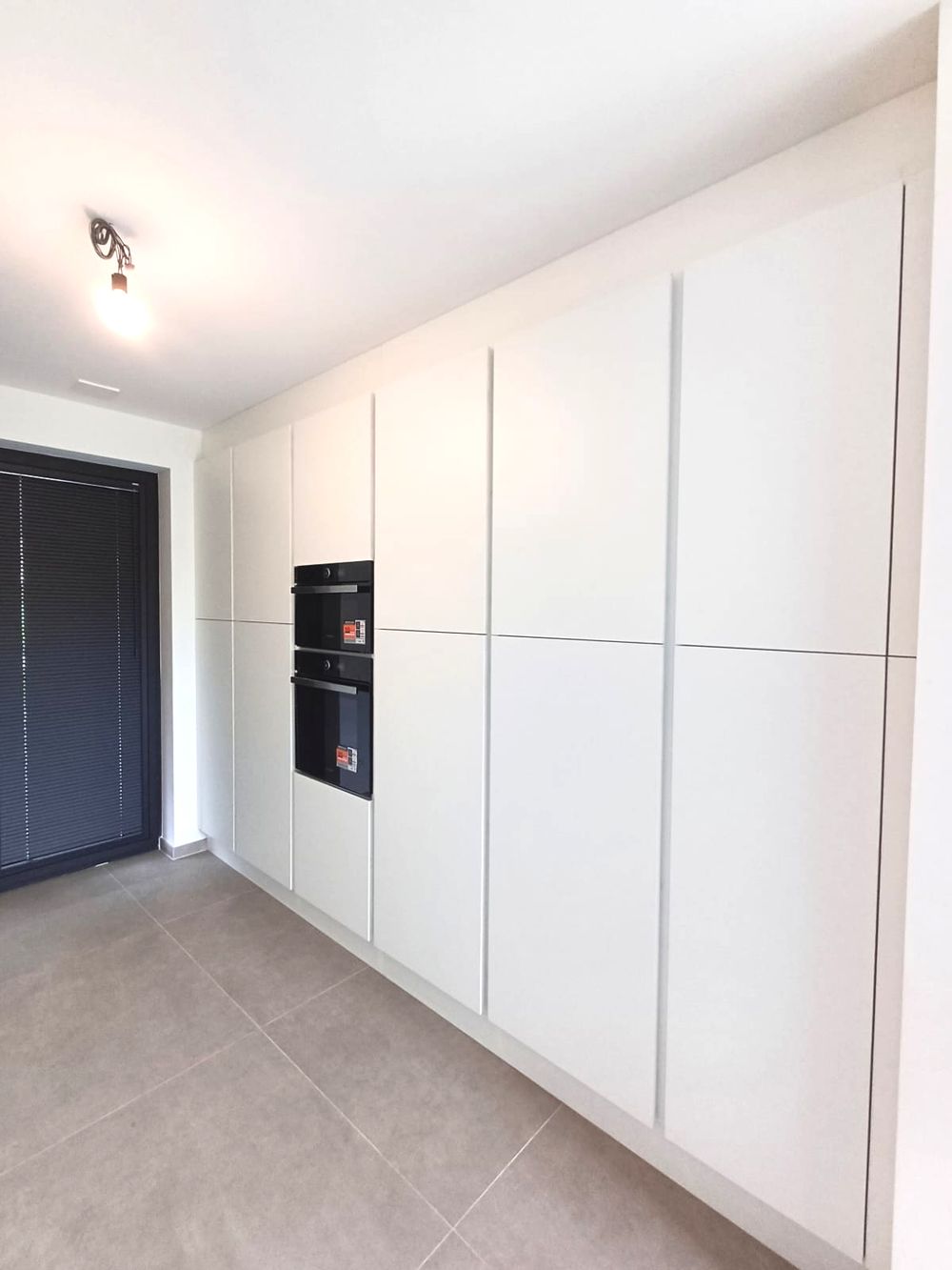 Witte kastenwand met inbouwovens